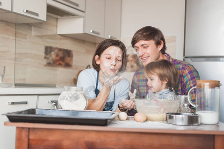 年幼父母和可爱的小孩在厨房图片