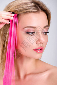 美丽的年轻美女运用粉红色剪短发束高清图片