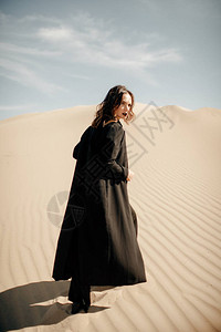 在沙漠中在沙丘上行走的身图片