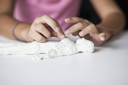 小女孩雕刻陶器人像双手特写图片