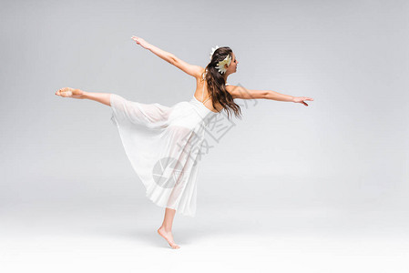 美丽优雅的芭蕾舞者穿着白色礼服在灰图片