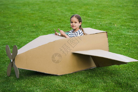 坐在玩具飞机上的可爱小女孩在公园的图片