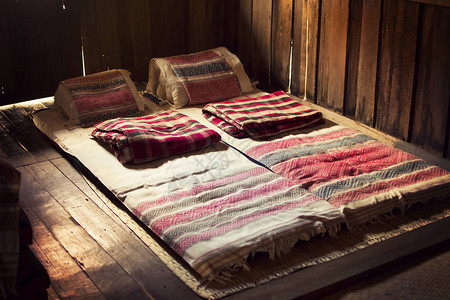 泰国南省旧木屋卧室的TaiLue本地床垫校背景图片