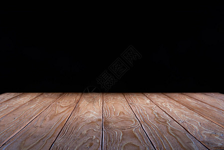 黑色背景上的空棕色木板表面背景图片