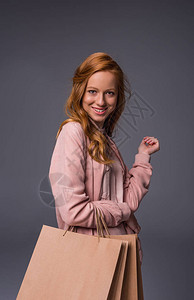 穿着粉红衣服拿着购物袋的时髦女人图片