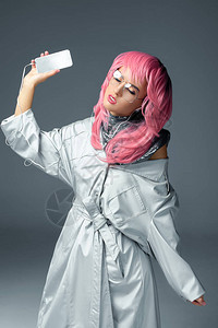 美丽的时装美女粉红色头发听音乐智能手机在图片