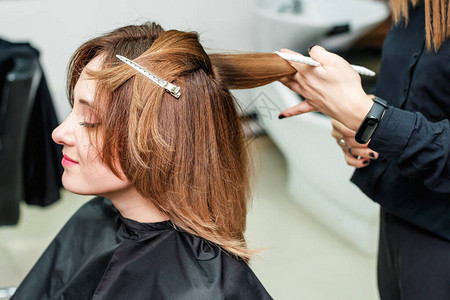 女理发师正在美容院给红发女孩做发型美发沙龙的图片