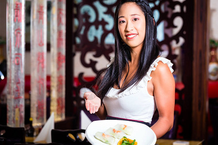 在亚洲餐厅吃寿司的女服务员图片