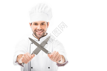 年轻大厨笑着的厨师拿着刀切成x形的刀图片