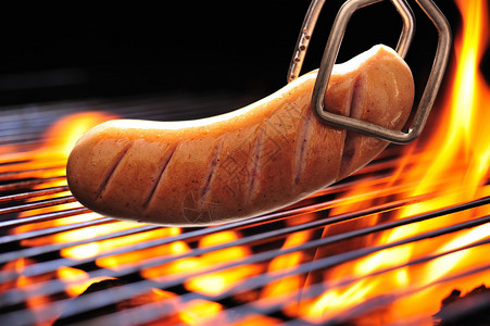 火焰状烤架上的烤香肠图片
