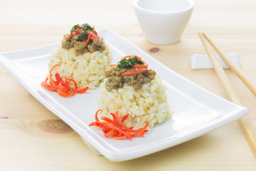 白矩形菜筷子和小白杯上含辣椒和巴西尔叶的咸猪肉图片