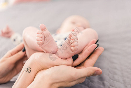 母亲和父亲把婴儿的脚抱在一图片