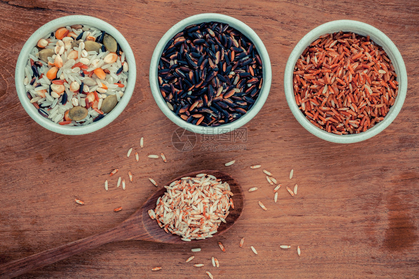 混合全麦传统泰国大米在勺子和碗里是柚木背景下健康和清洁食图片