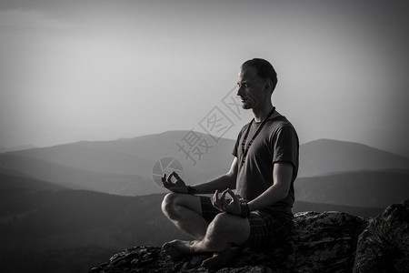 冥想在岩石上的人黑白照片图片