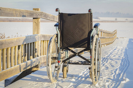 冬季湖边桥上的轮椅背景图片
