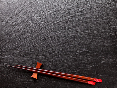 黑石背景上的日本寿司筷子带有复制空图片