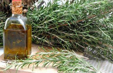一瓶橄榄油迷迭香叶包围图片