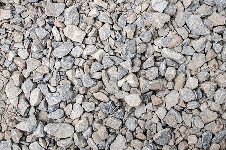 用于路面基础特写的碎灰色和米色砾石作为背景图片