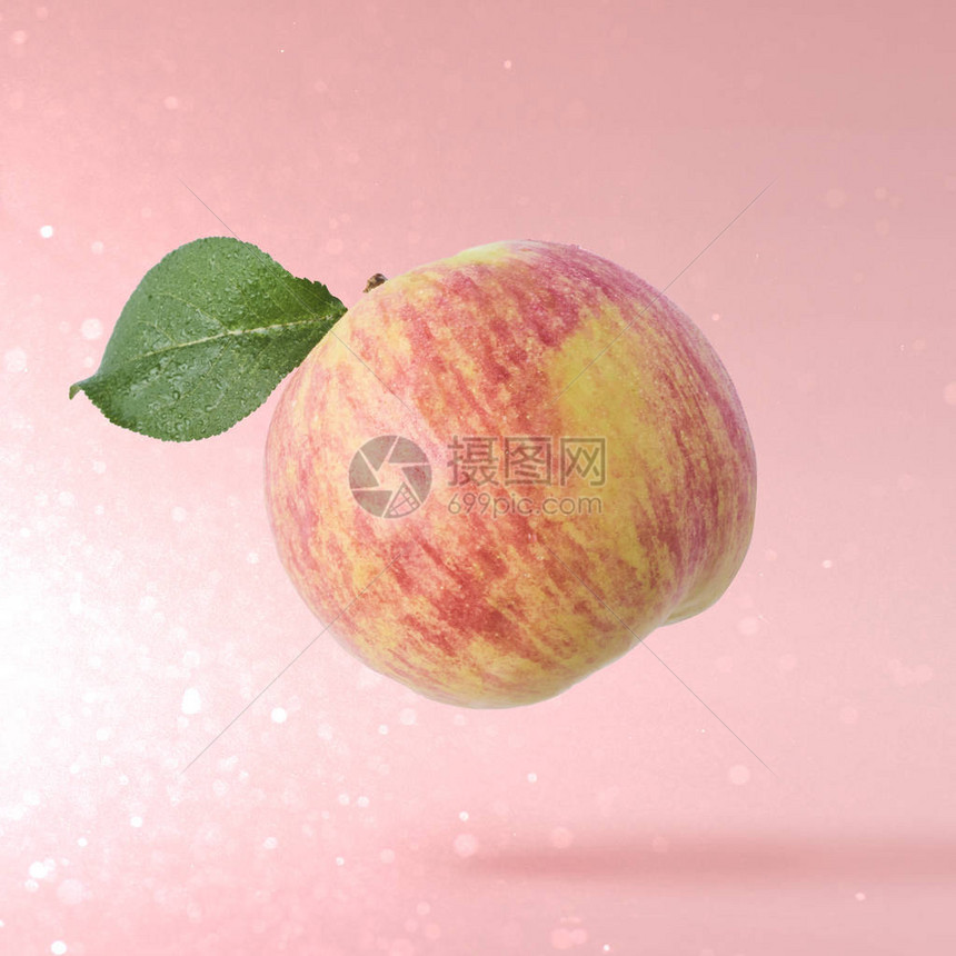 空中红鲜苹果飞过粉红色背景食品浮游图片