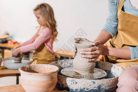 女儿在陶器车轮上做陶瓷锅时有选择焦点图片