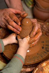 陶工的手创造了一个陶罐图片