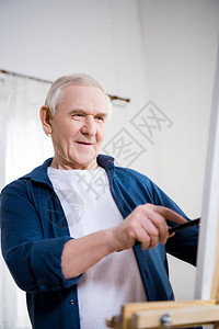在家画架上微笑的老人绘画图片