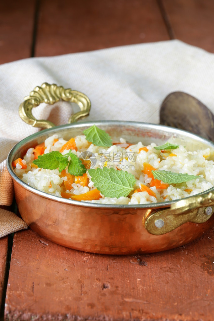 在铜锅中以印度风味烹制的蔬菜米饭图片
