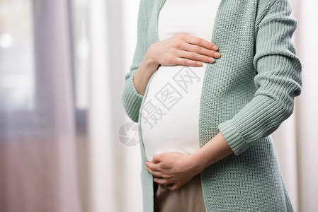 孕妇在室内抱着肚子的短片背景图片