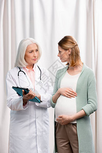 医生持有数字平板电脑与年轻孕图片