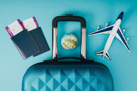地球仪和飞机模型旅行包和护照的顶视图图片