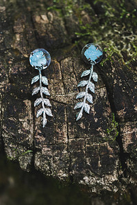 银色的婚礼耳环用蓝宝石戴在木图片