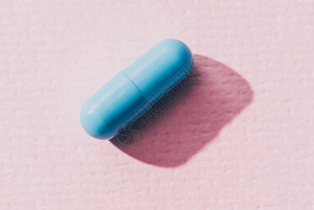 粉红色表面蓝色药物的近景背景图片