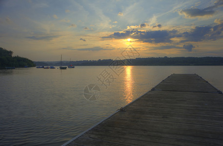 夏天日落在平静的湖面上长的木制式图片