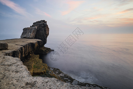 岩石悬崖景观与海洋上的日落图片