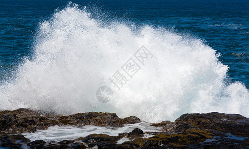 海浪在夏威夷KauaiQueensBath附近海岸边缘熔岩石上流背景图片