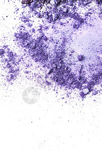 紫色化妆眼影的顶部视图洒在白色背景图片