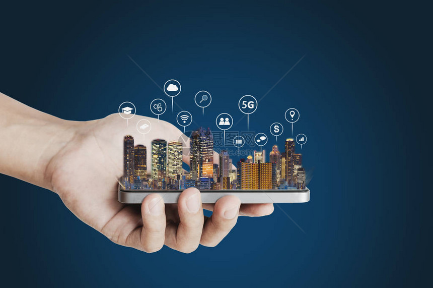 手持移动智能手机与建筑物全息图和技术图标智慧城市5g互联网区块链技术和图片