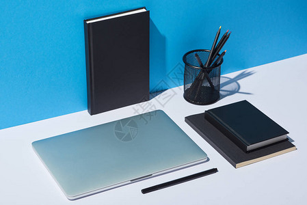 白桌上和蓝背景的笔记本和笔记背景图片