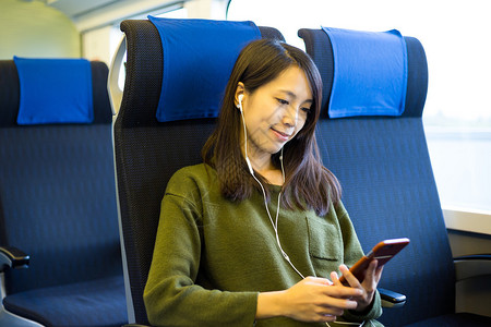 坐在火车厢里听音乐的亚洲图片