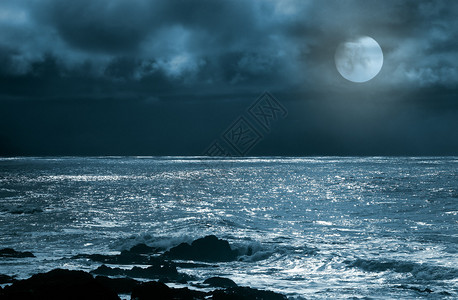 满月在海中升起在阴暗图片