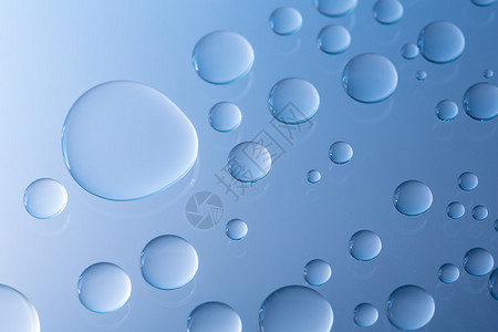 浸渍滴雨水对玻璃盘的纳米效应Nanoversiegelung浸渍与蓝色背景运行在工作室中创建背景图片