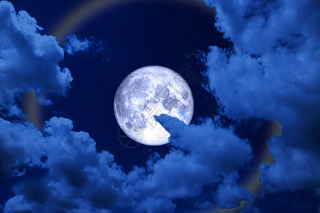 满蓝月光环月亮和彩色的夜云图片