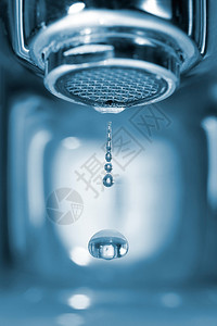 落水的滴形成一个水龙头在蓝色浴室里图片