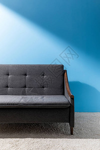 蓝墙前舒适的灰色沙发图片