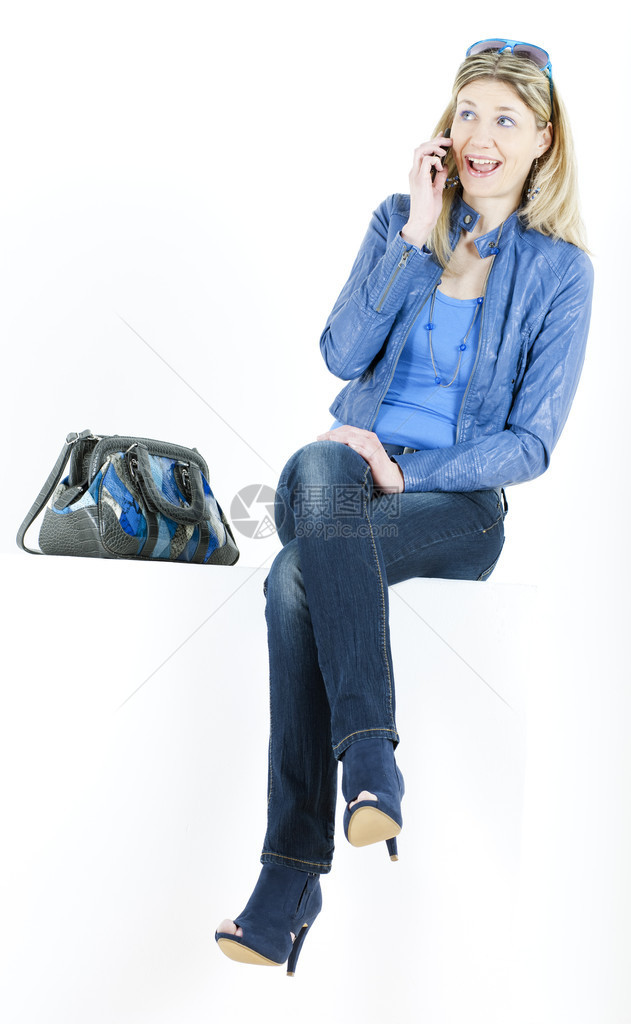 坐着拿手机和手提包的女人图片