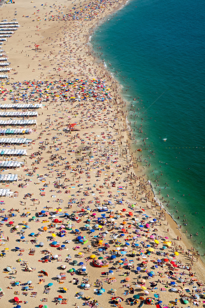 海滩上有很多人在葡萄牙纳扎尔N图片
