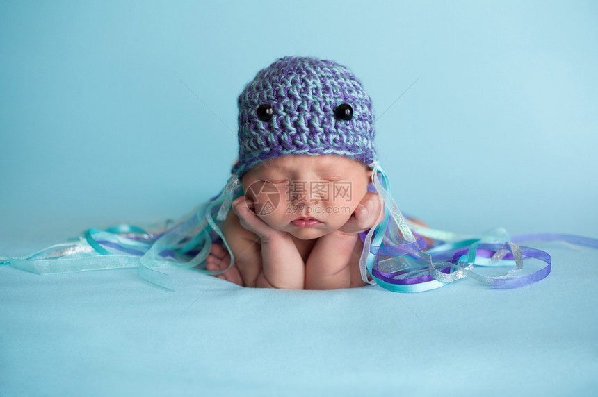 7天大的新生女婴戴着钩形水母帽睡图片