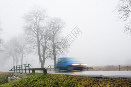 雾天运动模糊的蓝色汽车图片