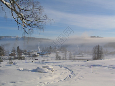 在山的早期和寒冷的冬天早晨背景是人工造雪机制造的雾前景雪地上的脚印和足迹这张照片是在芬兰斯堪的纳维亚欧洲的背景图片