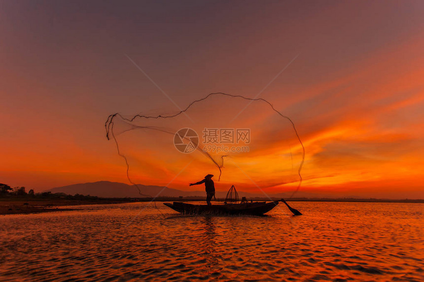 传统渔民在日出时扔鱼网打洞湖的轮光Silhouet图片